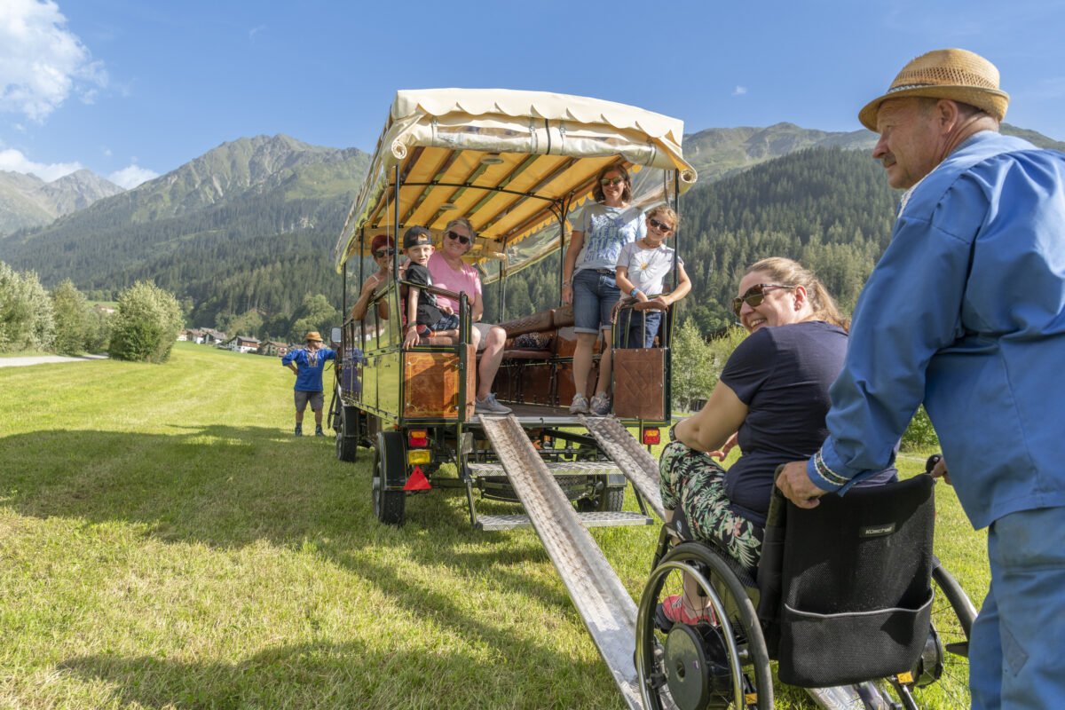 Carrozza trainata da cavalli con rampa di accesso per sedie a rotelle.