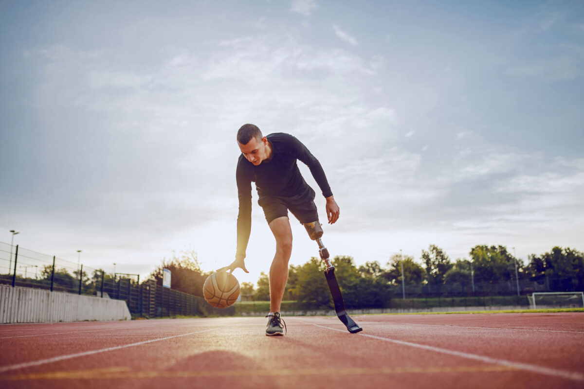 Un uomo con protesi alla gamba sinistra gioca a basket.